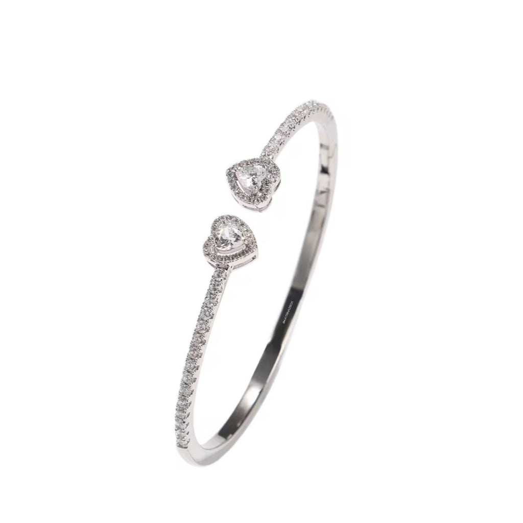 Silver bracelet with heart-shaped charms on a white background