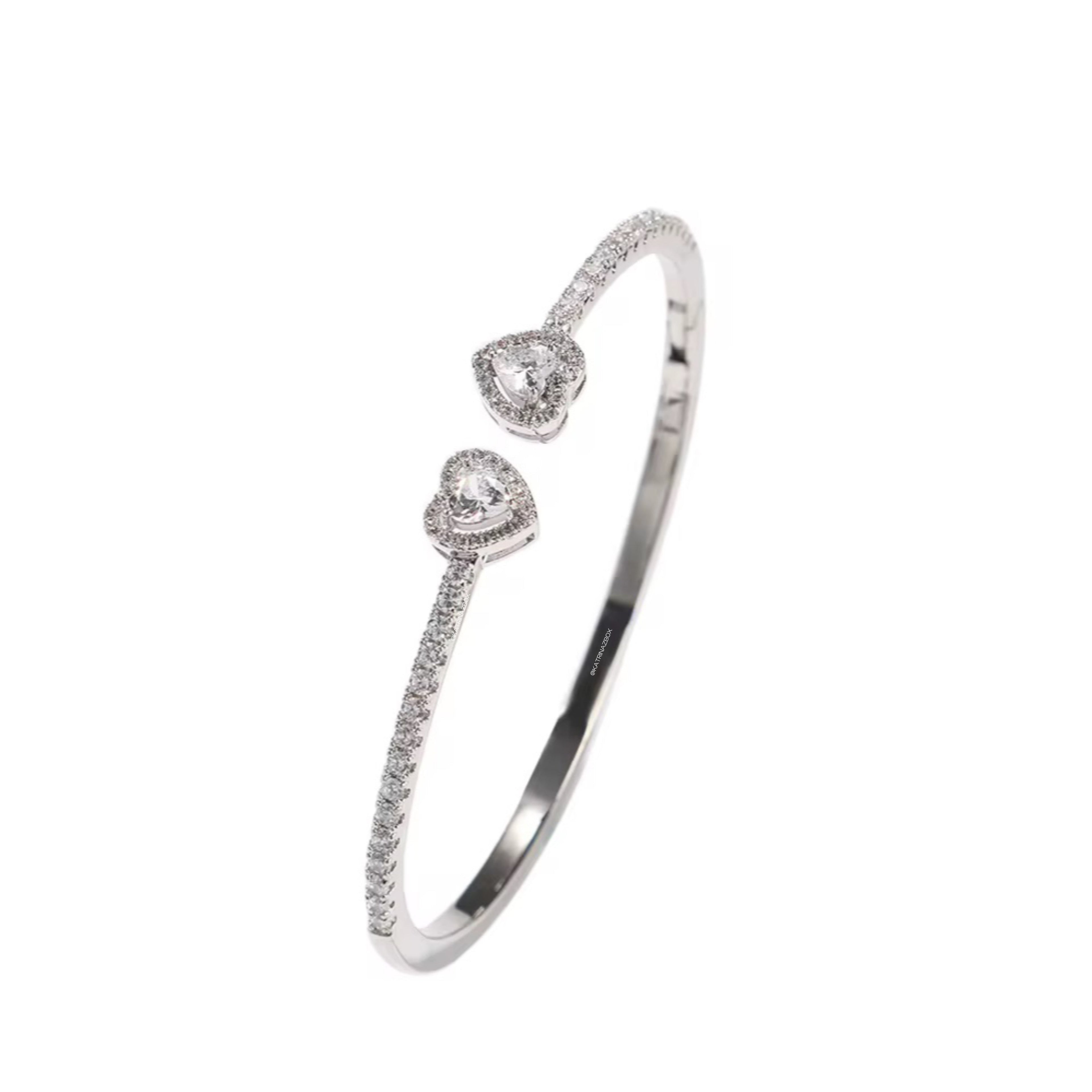 Silver bracelet with heart-shaped charms on a white background